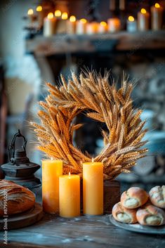 some candles are sitting on a table with bread and other food items in front of them