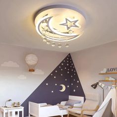 a child's room decorated in white and purple with stars, moon and crescent