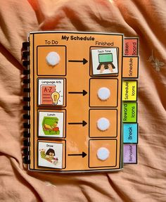 a book with pictures on it sitting on top of a pink bed spreaded in orange sheets