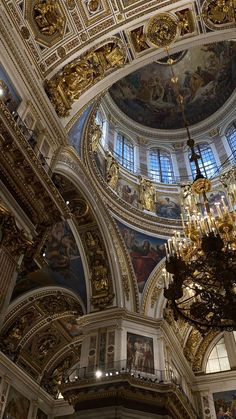 an ornate building with chandeliers and paintings on the ceiling