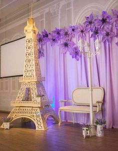 the eiffel tower is decorated with purple flowers and candles for an elegant event