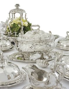 a table topped with lots of silver dishes