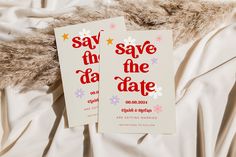 two save the date cards laying on top of a white bed sheet covered in fur