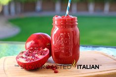 a close up of a pomegranate in a mason jar with a straw