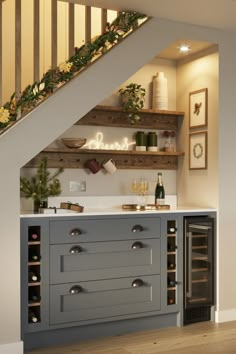 a kitchen under the stairs with wine bottles on it