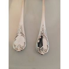 two silver spoons with ornate designs on them