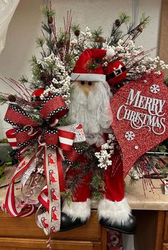 a christmas wreath with santa claus on it and decorations around the neck, sitting on a table