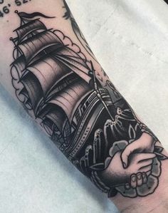 a man's arm with a ship on it and the words in black ink