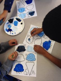 two children are painting clouds on paper plates