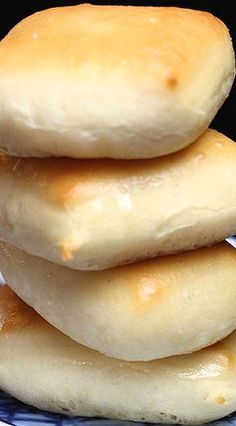 a stack of four doughnuts sitting on top of a blue and white plate