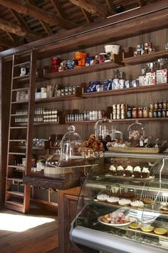 a bakery filled with lots of pastries and desserts on top of wooden shelves