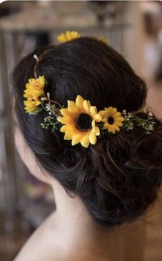 a woman with sunflowers in her hair is looking at the back of her head