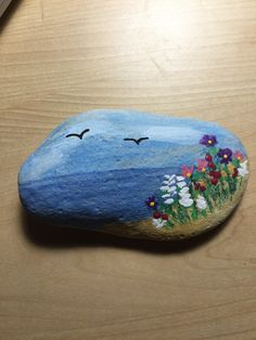 a painted rock sitting on top of a wooden table