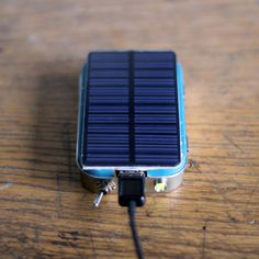 a small solar panel sitting on top of a wooden table