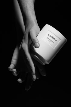 two hands reaching out to each other holding a container with the word liberine on it