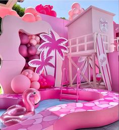 an inflatable pink flamingo pool with palm trees and beach ball pit on the ground