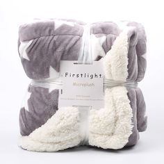 the firstlight microplush blanket in grey and white is folded on top of each other