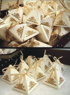 there are many small boxes that have bows on the top and bottom one is white with gold designs