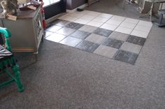 a kitchen with tile flooring and green chair in the middle, next to a window