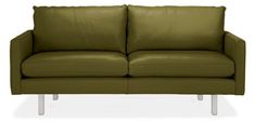 a green leather couch sitting next to a white wall