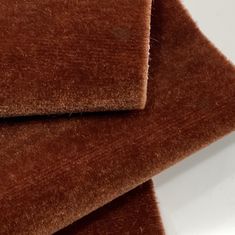 two pieces of brown fabric sitting next to each other on top of a white table