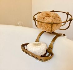 a white bath tub with a soap dish on top of it and a towel rack attached to the wall