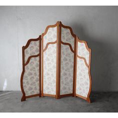 a room divider made out of wood and fabric with floral designs on the sides