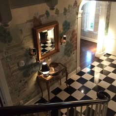 the hallway is decorated with black and white checkered flooring, wallpapered walls, and an ornate mirror