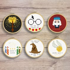 six cross stitch hoop art designs on wooden background