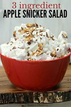 a red bowl filled with whipped cream and toppings on top of a wooden table