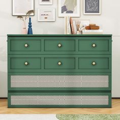 a green dresser with pictures on the wall