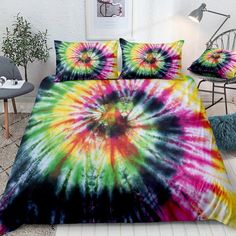 a bed covered in a colorful tie - dyed comforter