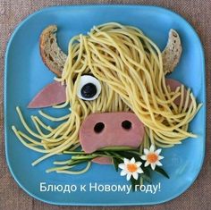 a blue plate topped with spaghetti and a cow's head