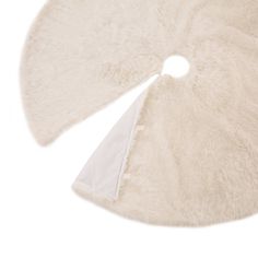 a white round rug with two pieces of fur on it