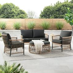 an outdoor patio with black furniture and plants