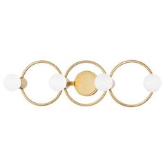 an image of three circles on a white wall mounted light with gold metal fittings