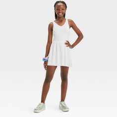 Why we're ALL IN: Solid-color sleeveless active dress with built-in shorts and a pleated skirt. Made from recycled polyester fabric with added spandex for flexible wear. Boasts moisture-wicking and quick-drying construction for comfort during any activity. The hidden pocket, built-in shorts, V-neckline and keyhole cut-out back complete the sporty design. All in Motion™: Inspiring the potential in every body. Spring Skirted Tennis Dress For Sports, Spring Sports Tennis Dress With Skirt, Casual Summer School Dresses, Spring Skirted Sporty Tennis Dress, Summer School Mini Dress, Stretch Skirted Tennis Dress For Spring, Casual Tennis Skirt For School In Summer, Casual Mini Dress For School In Spring, Casual Solid Dresses For School