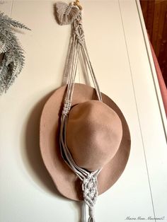 a hat hanging on the wall with rope