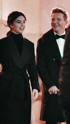 two people in tuxedos standing next to each other