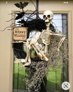 a skeleton sitting in front of a door decorated for halloween