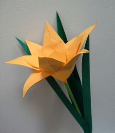 an origami flower is placed on the wall