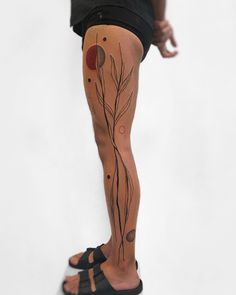 a person with some tattoos on their legs and one leg is covered in black ink