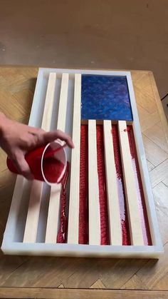 someone is painting an american flag with red, white and blue paint