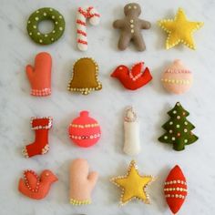 a collection of decorated christmas cookies on a white counter top with ornaments and decorations around them