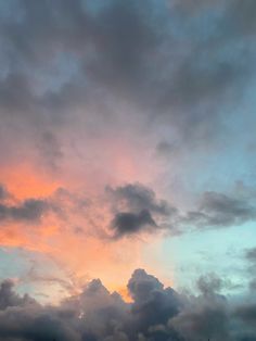 an airplane is flying in the sky with clouds around it at sunset or sunrise time