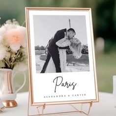 a wedding photo frame with the word paris on it next to flowers and a vase