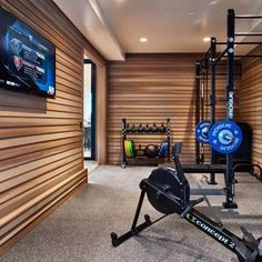 a home gym with an exercise bike, rowing machine and other equipment in the room