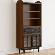 an old fashioned bookcase in the corner of a room with wood floors and white walls