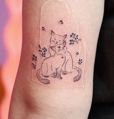 a cat and dog tattoo on the arm