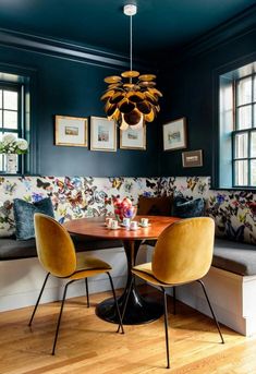 a dining room with blue walls and yellow chairs